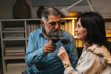 close up of couple holding wine glasses and cheers