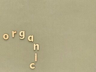 Word Organic with natural wooden letters on green background, copy space