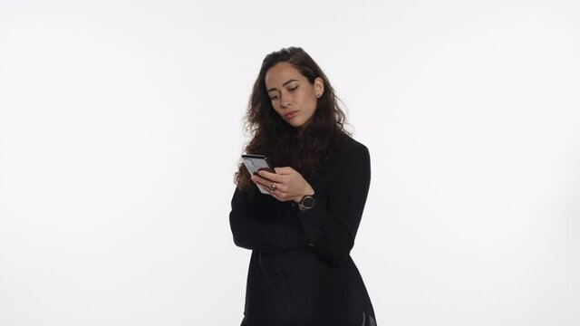 Young mixed race woman steps out and looks at smartphone