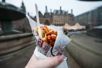 POV of a man holding and eating Gyro outside. Traditional Greek fast food