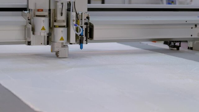 Digital cutting and creasing plotter - cnc flatbed cutter during work at factory, exhibition. Automated technology, industrial, robotic, electronic, production, manufacturing concept