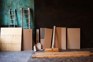 The interior of a loft-style studio in the process of renovation. Building materials and boxes on a background of repainted walls with copy space.