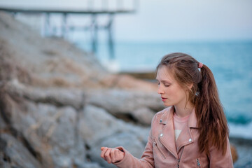 Fototapeta na wymiar Garmony meditation, girl hand picking up heart from stones, relaxed hobby rest near sea