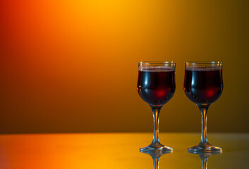 Two glasses of red wine on a blurred homogeneous background. Horizontal photo