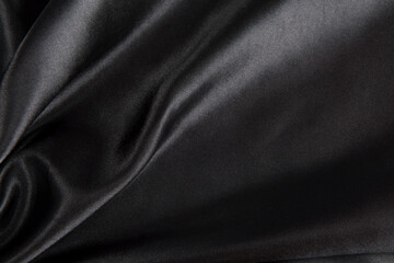 Abstract black silk fabric texture background. Cloth soft wave. Creases of satin