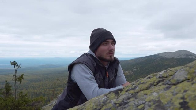 Hicker Climb to the Top of the Cliff, Relaxes and Finds Calm. Looks Through the Verses and Receives Pleasure. The concept of Solitude and Love for Nature