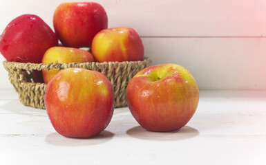 Two apples with water drops put on wooden board,