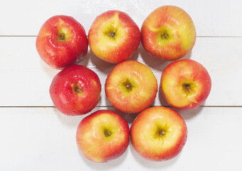Top view of apples with water drops around put on wooden board,