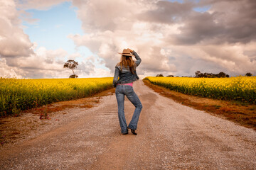 Aussie country girl standing on dirt road in farm fields