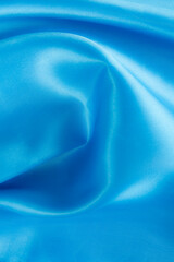 Abstract blue silk fabric texture background. Cloth soft wave. Creases of satin