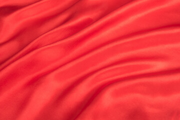 Abstract red silk fabric texture background. Cloth soft wave. Creases of satin