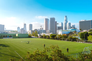 Obraz premium Green football field with views of downtown and high-rise buildings. Los Angeles, USA - 16 Apr 2021
