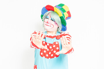 白背景の前でNGのジェスチャーをするピエロ