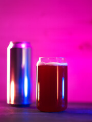 Creative glass in the shape of a beer can. Craft Red fruit beer on a bright neon background, aluminum beer can