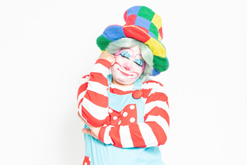 白背景の前で考えるジェスチャーをするピエロ