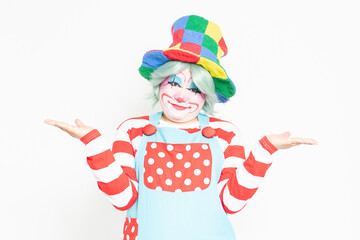 白背景の前で案内のジェスチャーをするピエロ