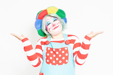 白背景の前で案内のジェスチャーをするピエロ