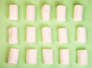 Marshmallow pattern close-up on a green background. Summer concept. Top view.