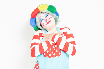 白背景の前に立って、胸に手を当てるピエロ