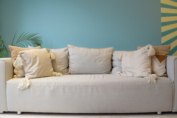 Large bright living room with a sofa with a bright blue wall. Nice interior, apartment