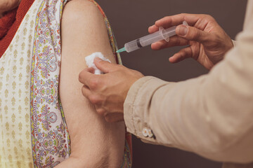 an emergency doctor vaccinating an elderly lady