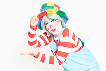 白背景の前に立って、納得のジェスチャーをするピエロ