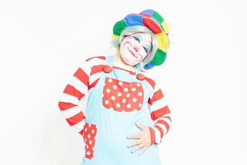 白背景の前に立って、お腹に手を当てるピエロ