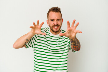 Young tattooed caucasian man isolated on white background upset screaming with tense hands.