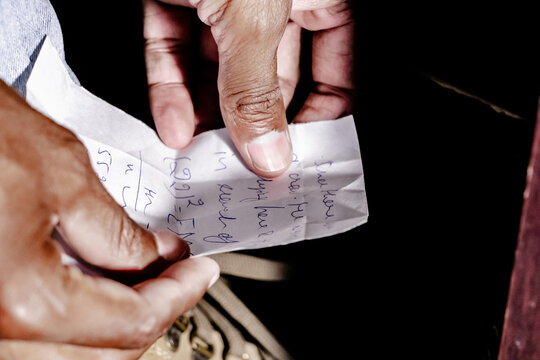 Math formulas and equations written on a paper chit for cheating in the examination with only fingers in shot.