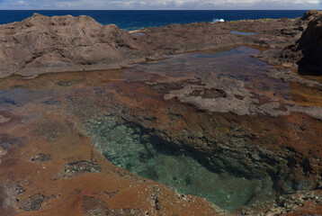 Gran Canaria, calm natural seawater pools in under the steep cliffs of the north coast, separated from the ocean by 
volcanic rock, Punta de Galdar area
