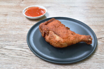 crispy fried chicken tight and leg on plate dipping chili sauce cup