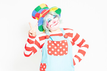 白背景の前に立って、指で数字を示すピエロ