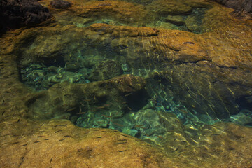 Gran Canaria, calm natural seawater pools in under the steep cliffs of the north coast, separated from the ocean by 
volcanic rock, Punta de Galdar area
