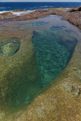 Gran Canaria, calm natural seawater pools in under the steep cliffs of the north coast, separated from the ocean by 
volcanic rock, Punta de Galdar area
