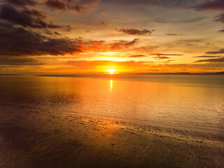 Obraz premium Beautiful sunset colors over the coastline of Allerdale district in Cumbria, UK. Sun setting over the shore of Allonby bay on autumn.