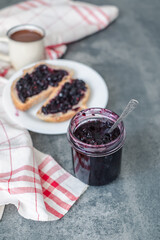Fototapeta na wymiar jar blueberry jam with a spoon in the middle. Healthy breakfast