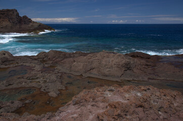 Gran Canaria, calm natural seawater pools in under the steep cliffs of the north coast, separated from the ocean by 
volcanic rock, Punta de Galdar area
