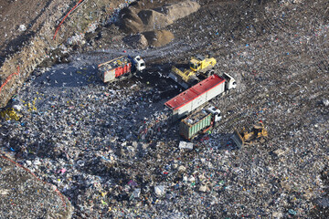 Aerial view taken from a helicopter of a landfill site in the UK. It contains trucks and machinery depositing rubbish as well as hundreds of gulls feeding on the garbage.