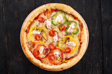 Pizza with bell pepper and mozzarella on the dark wooden background