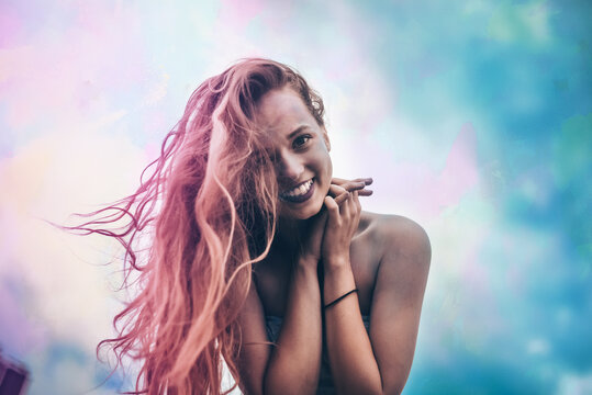 Holi Festival Of Colours. Portrait of happy young pretty girl on holi color festival. Girl kiss with colorful long pink and blue hair . Colorful powder paint on dress. Energy, dancing, beautiful woman