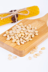 pine nuts, not fried, raw, on a wooden board, on a white background