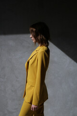 Fashionable young woman in yellow tailored suit.