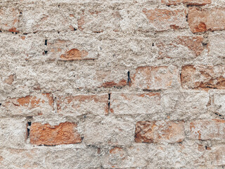 Brown brick and crumbling plaster. Old wall texture