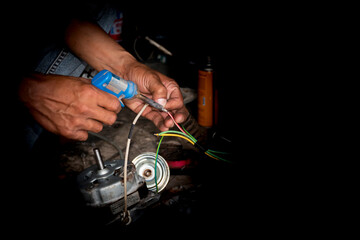 The mechanic's hand is repairing the electric motor. And there is a black space