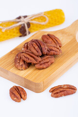 pecan nuts, halves, fried, on a wooden board, on a white background