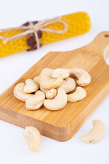 cashew nuts, not fried, large, on a wooden board, on a white background