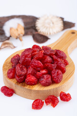 ripe dried cherry, without bones, on a wooden board, on a white background