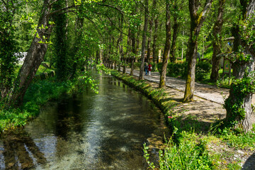 People walking on Scheggino riverside on a sunny spring day, Perugia, Valnerina, Umbria, Italy