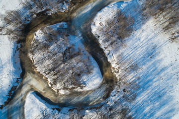 Beautiful Sunny landscape with forest, snow and frozen river. Aerial photography from a drone