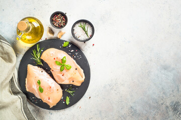 Chicken fillet with spices and herbs at white table.